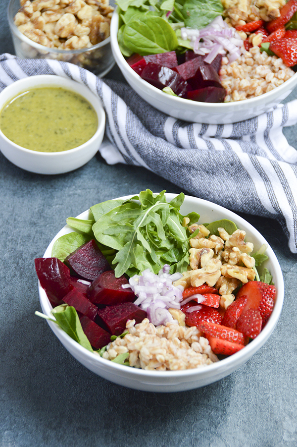 Roasted Beet & Walnut Grain Bowl - This hearty grain bowl is made with roasted beets, farro, strawberries, walnuts, arugula and topped with a delicious basil vinaigrette. #buddhabowl #grainbowl #healthyrecipe #vegetarian #plantbased