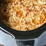 Stupid-Easy Slow Cooker Shredded Mexican Kitchen - Only three ingredients needed to make this easy shredded Mexican chicken. Just pop it in the slow cooker and you'll have a delicious, flavorful chicken recipe. #chickenrecipe #chicken #slowcookerrecipe #recipe #slowcooker